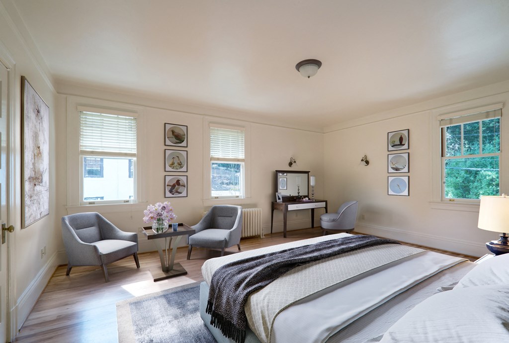 a bedroom with a bed and two chairs and a table