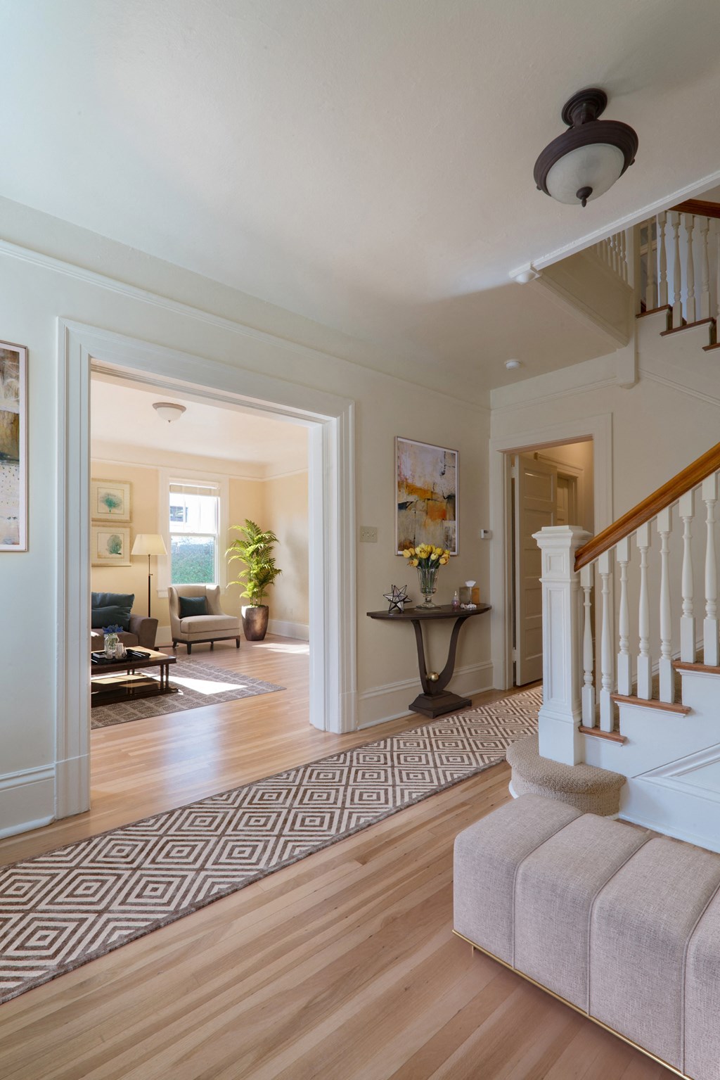 a living room with a staircase and a rug in a house