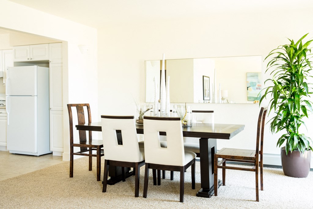 a dining room with a table and chairs and a plant