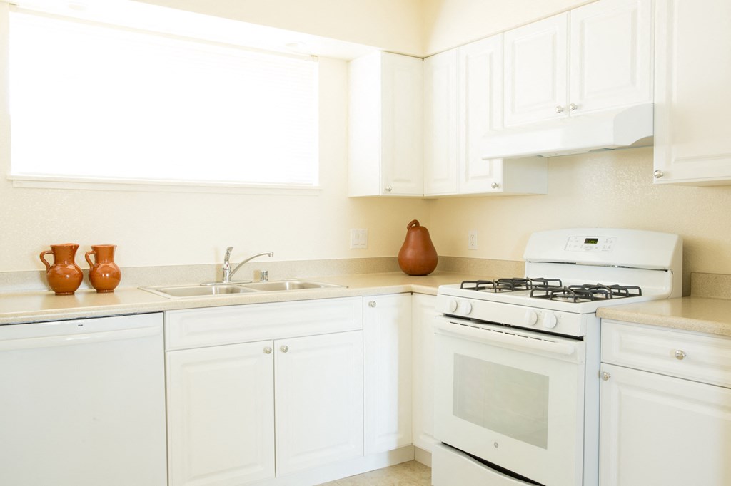 a kitchen with white appliances and white cabinets