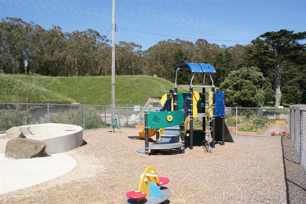 a playground with a blue and yellow swing set