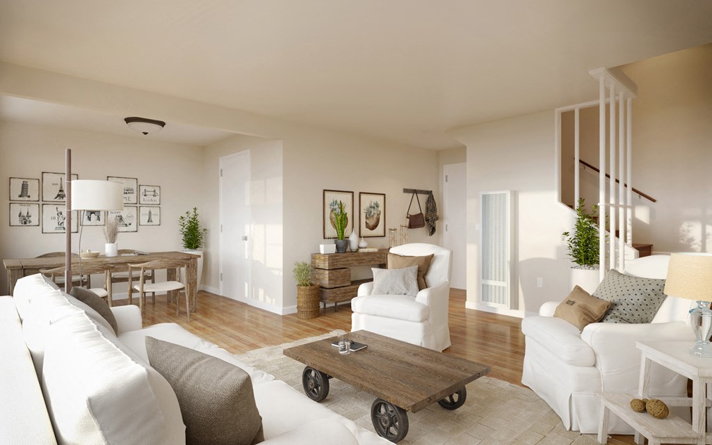 a living room and dining room with white furniture and a wooden table