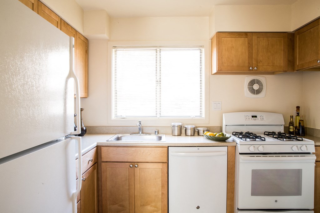 a kitchen with white appliances and wooden cabinets