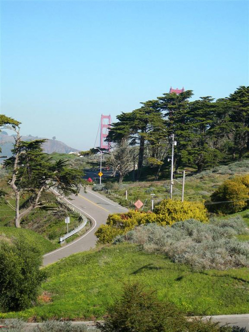 a road with a suspension bridge in the background