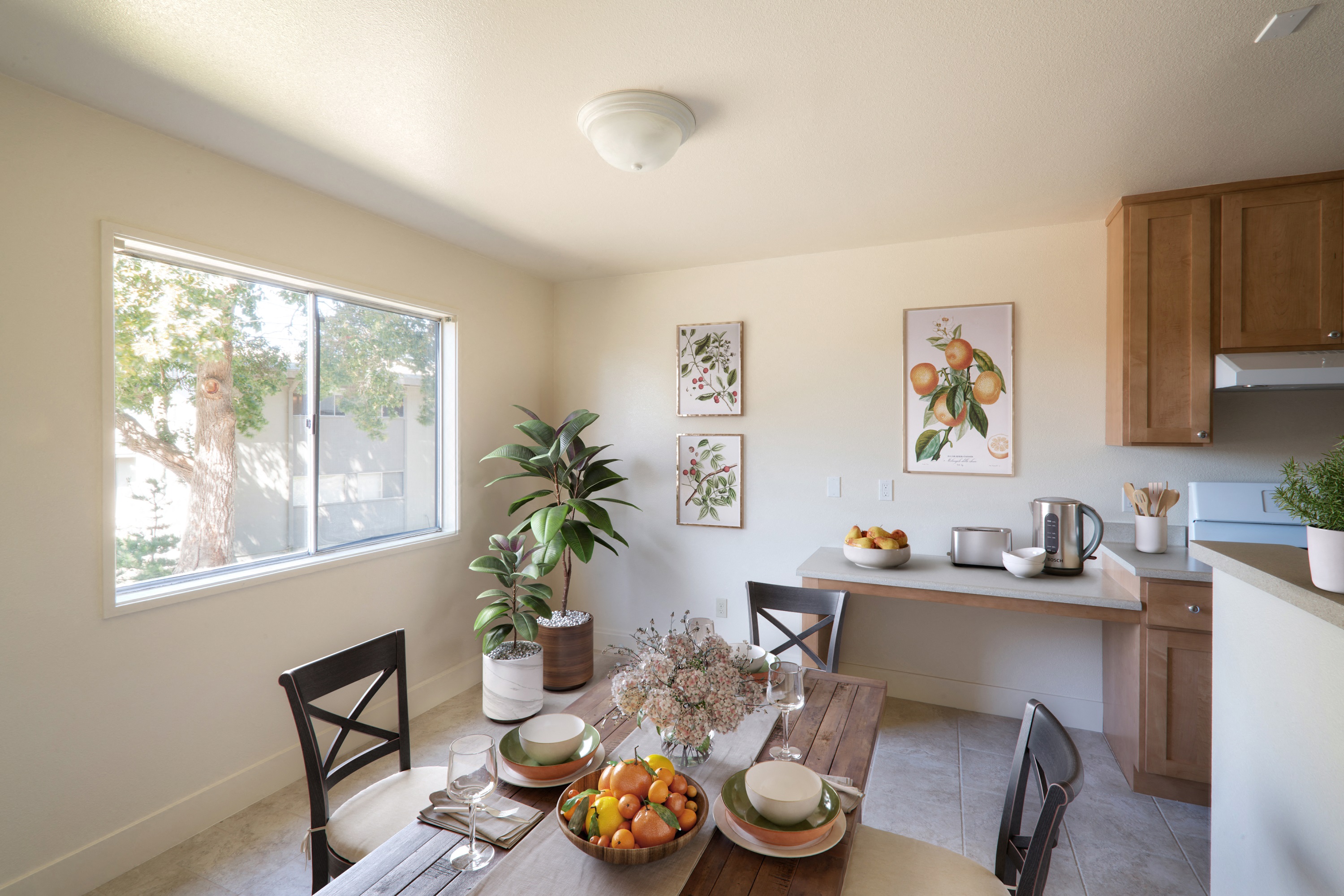 the dining room and kitchen of a house with a table and chairs