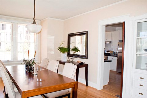 a dining room with a wooden table and white chairs