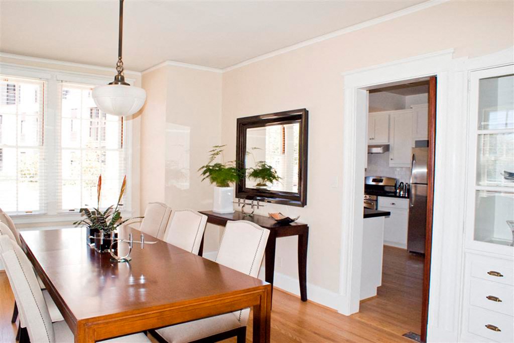 a dining room with a wooden table and white chairs