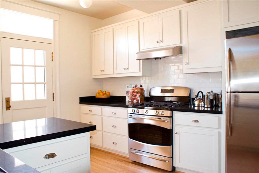 a kitchen with stainless steel appliances and white cabinets