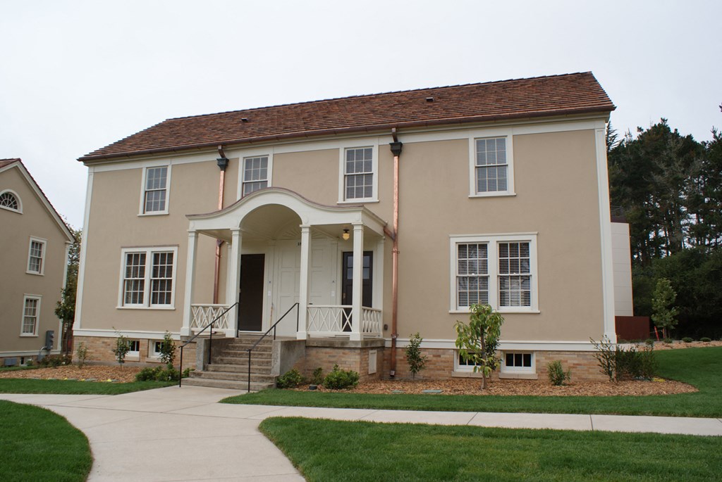the front of a house with a sidewalk and grass