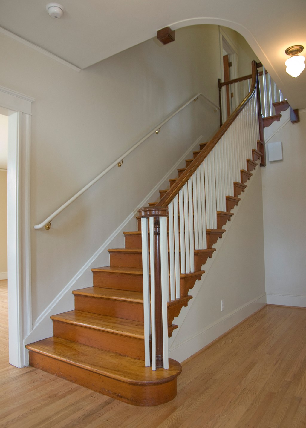 a view of a staircase in a home with wood floors and white walls
