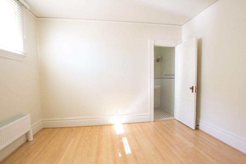 an empty living room with a door to a bathroom