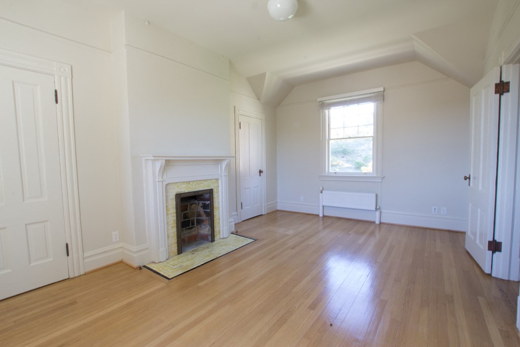 a living room with a fireplace and a wooden floor