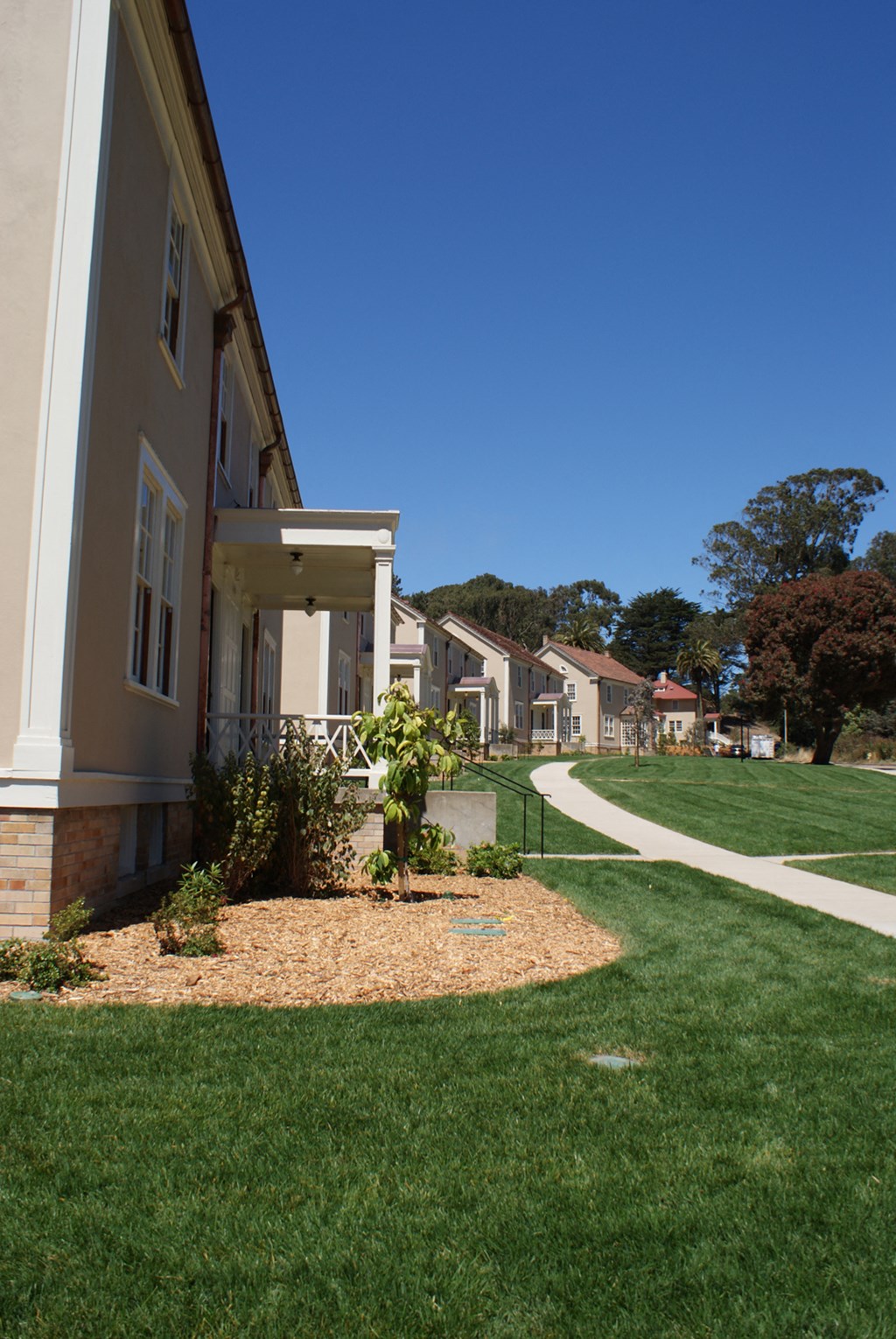 a row of houses on a street with a sidewalk