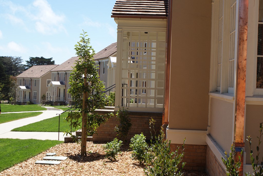 a side view of a house with a porch and a garden