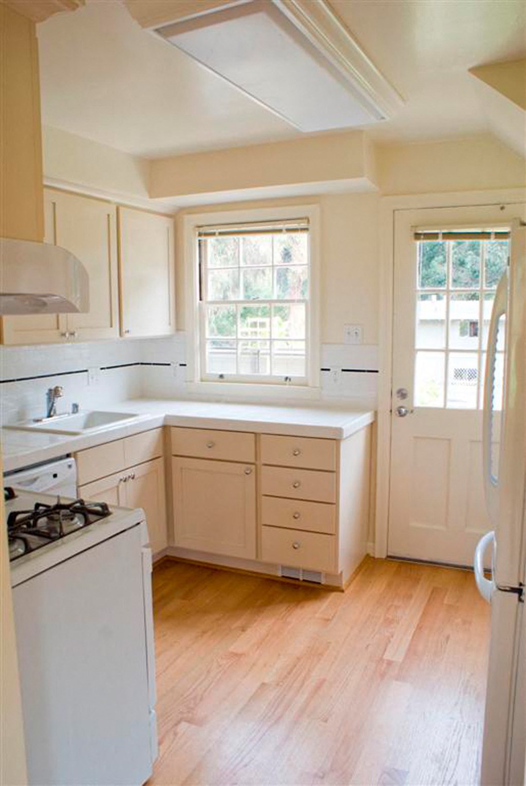 a kitchen with white cabinets and a stove and a window
