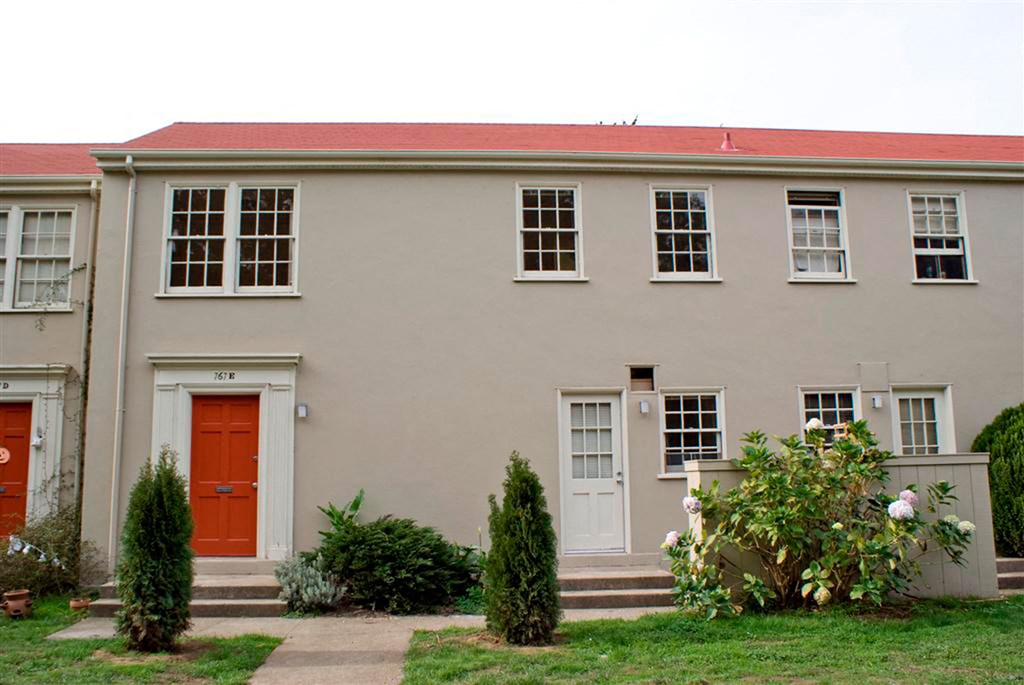 the front of a white building with a red door