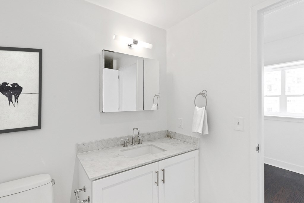 an all white bathroom with a sink and a mirror
