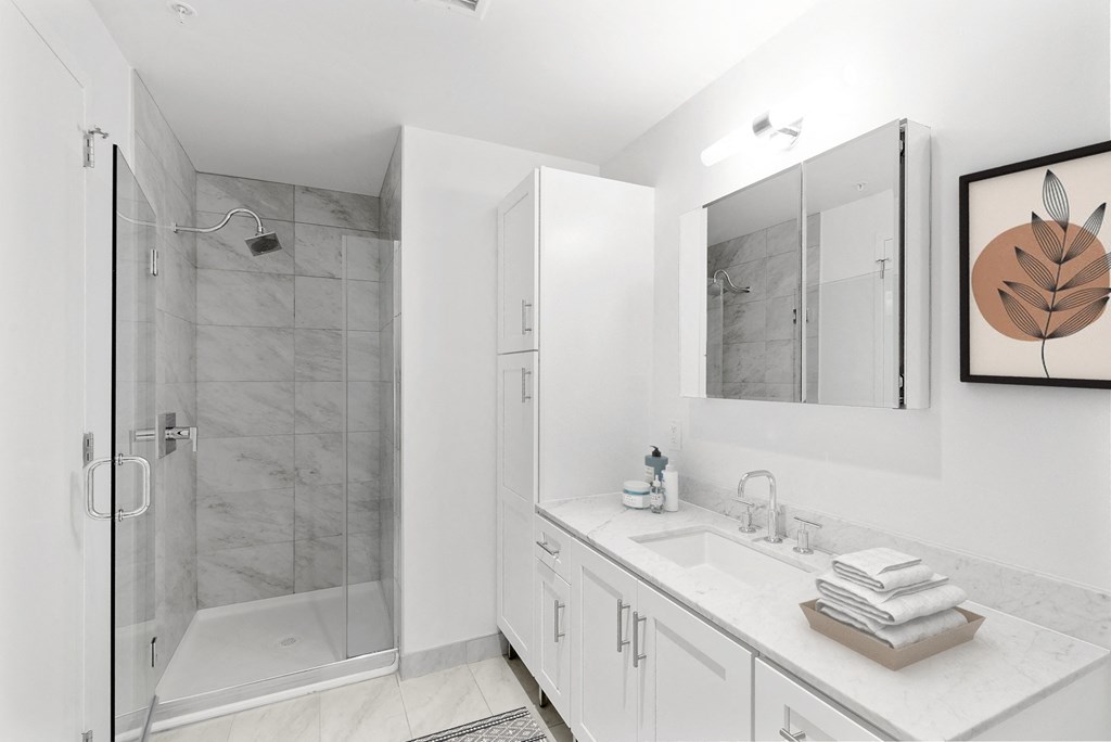 a white bathroom with a shower and a sink