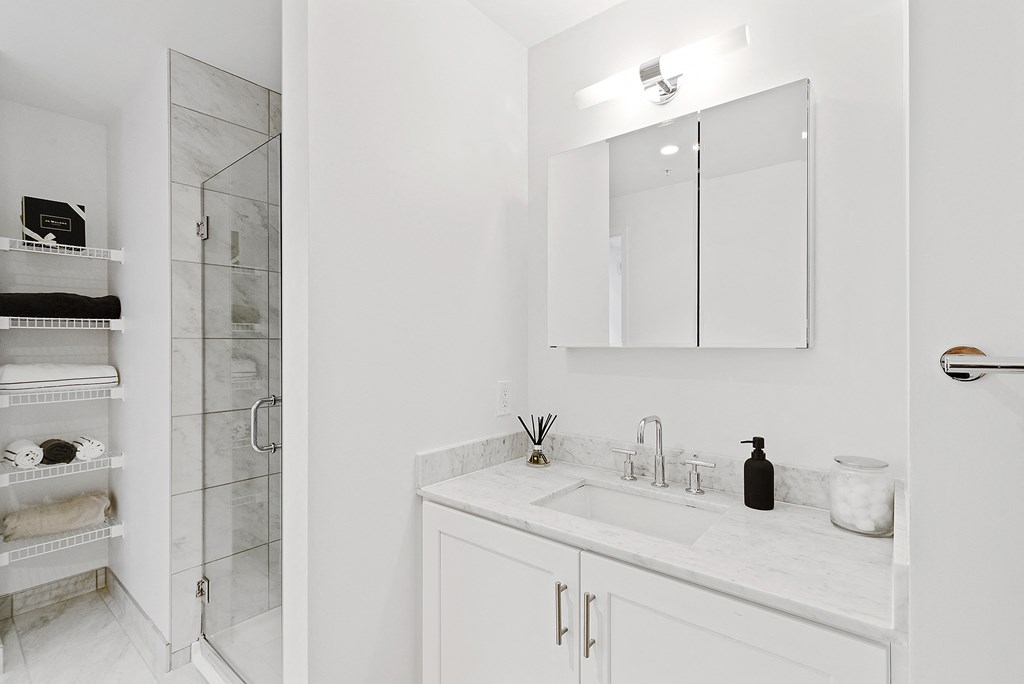 a white bathroom with a sink and a shower