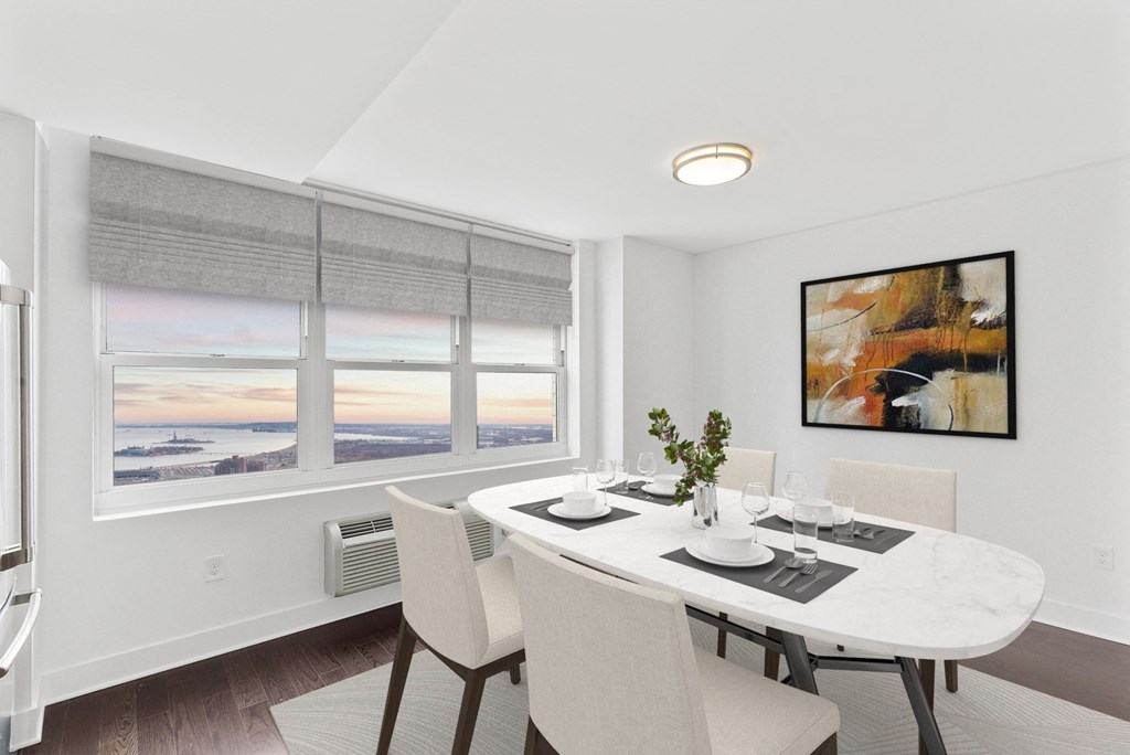 a dining room with a white table and chairs and two windows