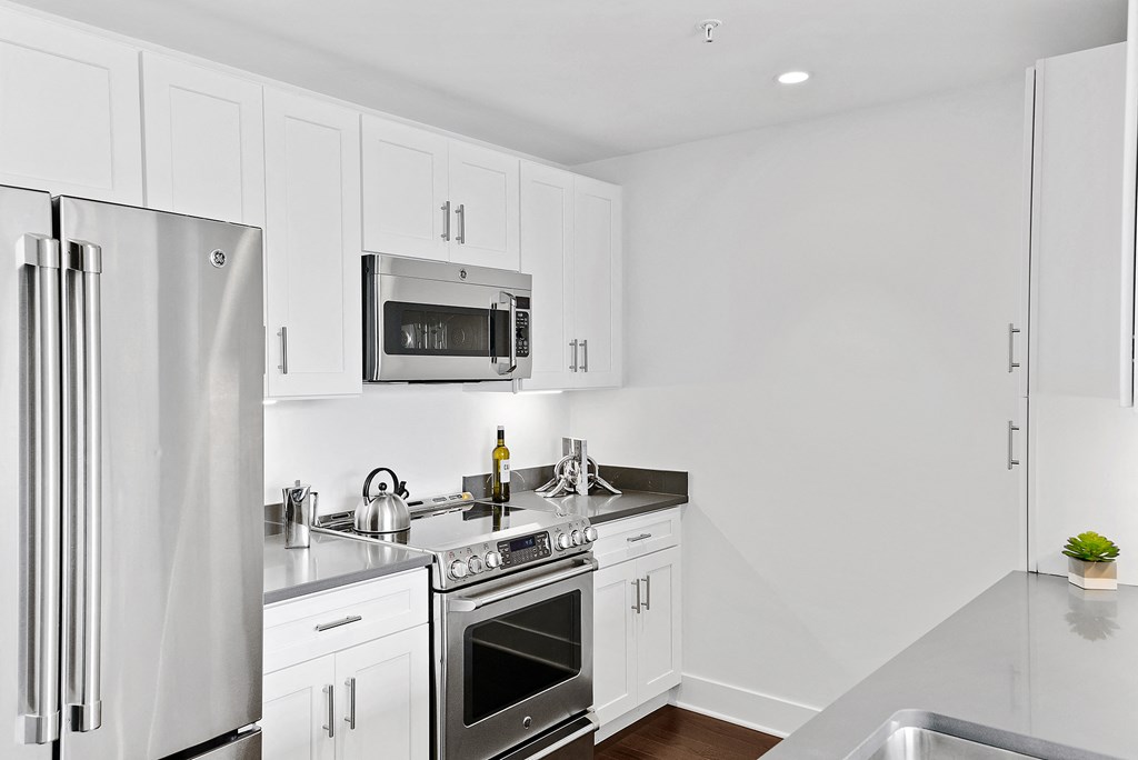 a white kitchen with stainless steel appliances and white cabinets