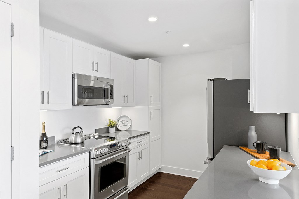 a kitchen with white cabinets and stainless steel appliances
