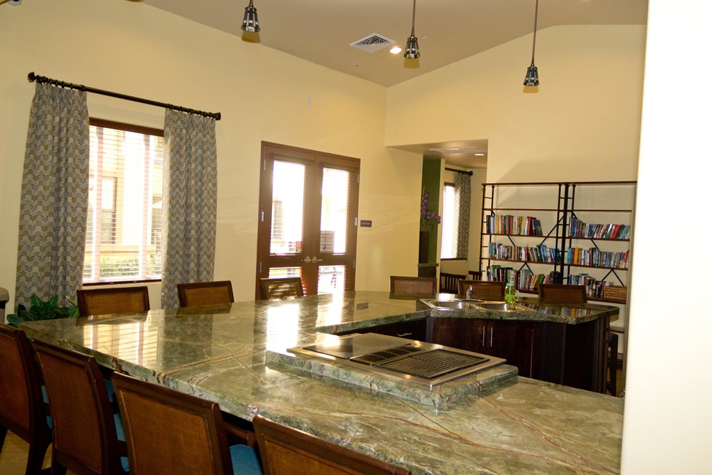 an open kitchen and living room with a marble counter top