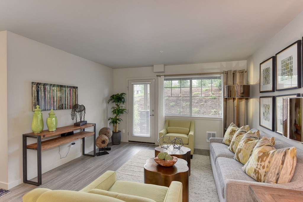 Dining Area with Wood Inspired Floor, Lime Green Chairs, Grey Sofas/ Chairs, Open View Windows, Brown Decorative Tables with Fruitbowl