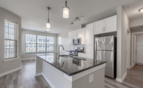 A modern kitchen with a large island and stainless steel appliances.