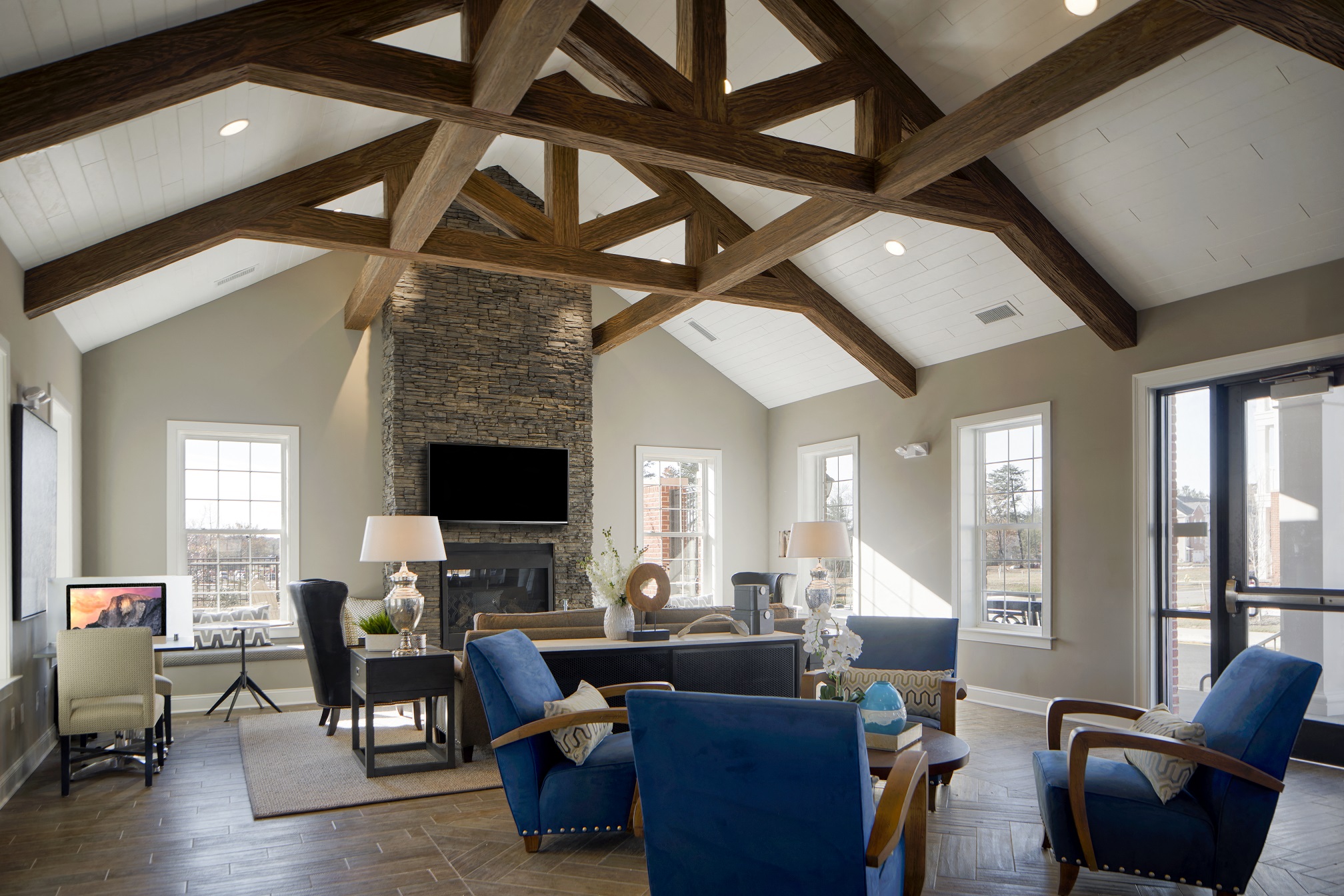 a living room with a stone fireplace and blue furniture