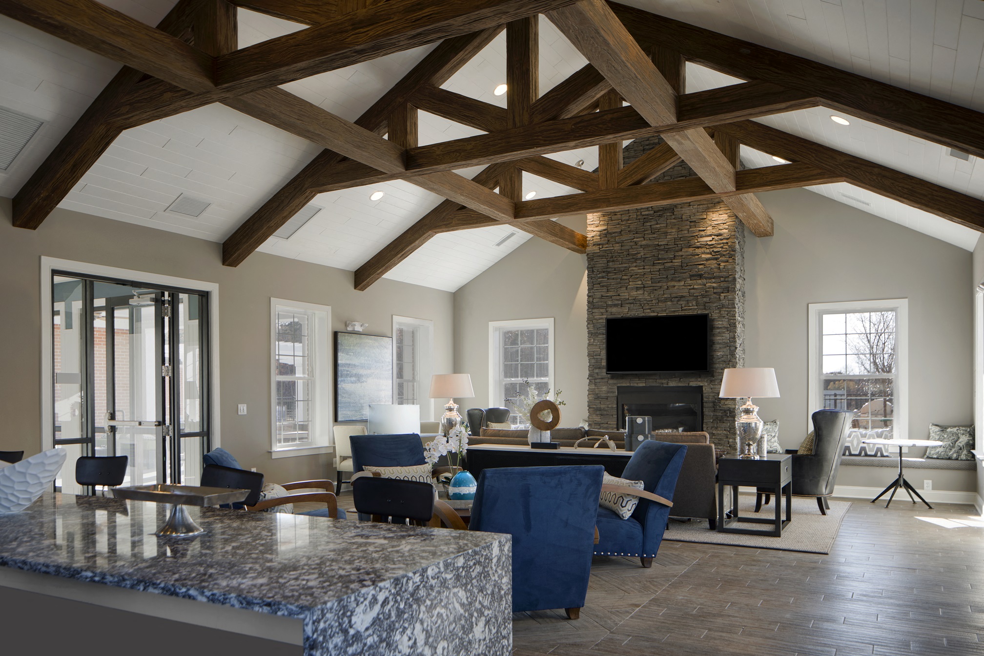 a living room with a stone fireplace and a dining room