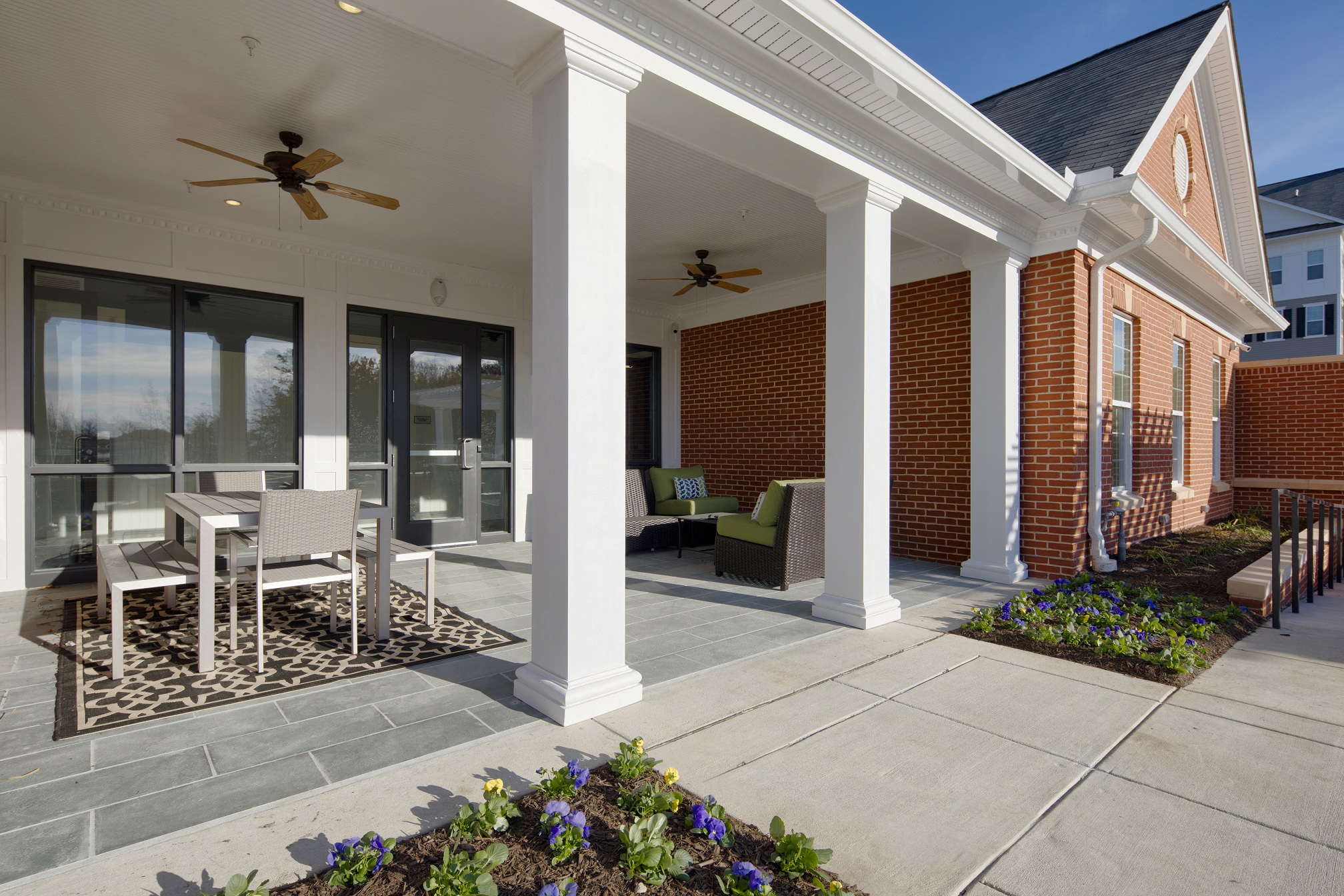 a patio with a table and chairs in front of a house