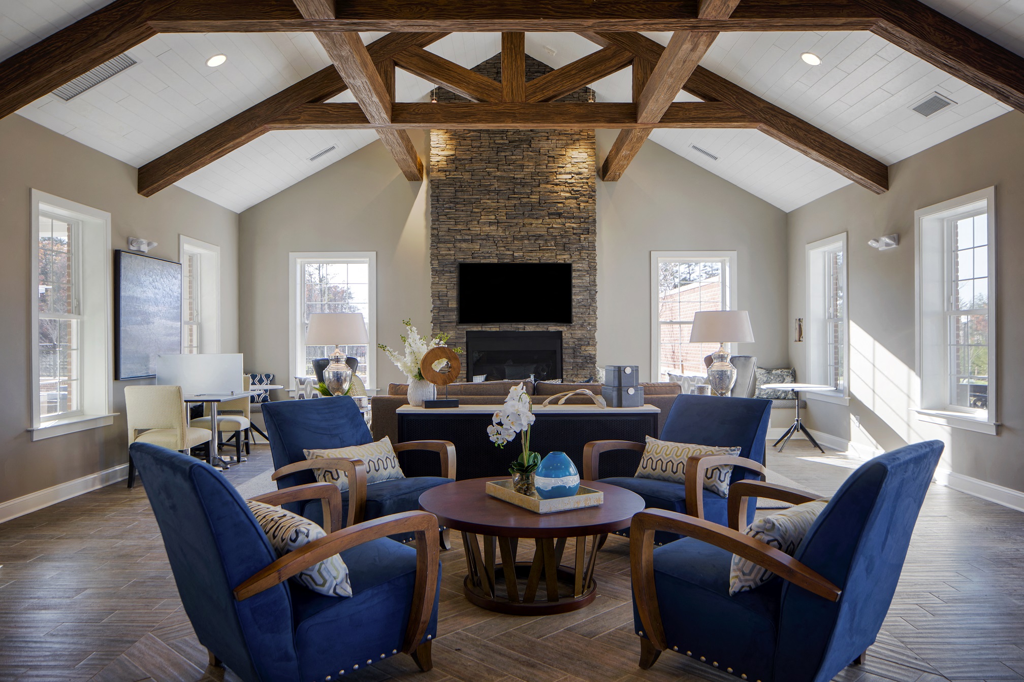 a living room with blue chairs and a stone fireplace