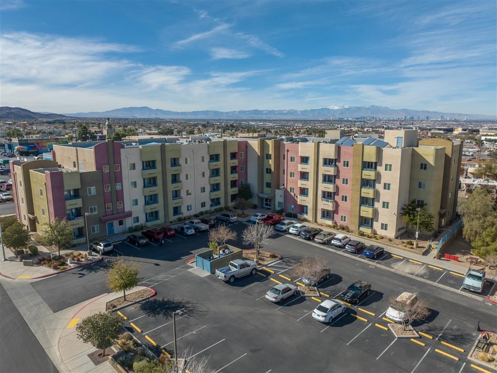 an aerial view of an apartment complex with cars parked in a parking lot