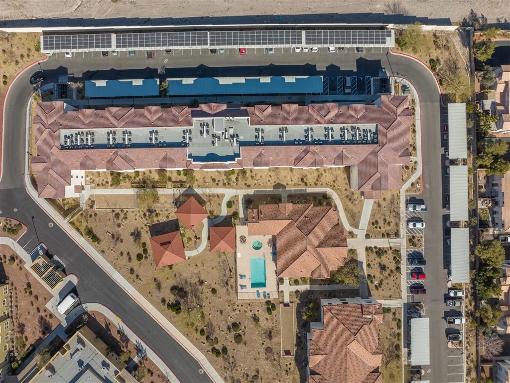 an aerial view of a building with a parking lot and a road