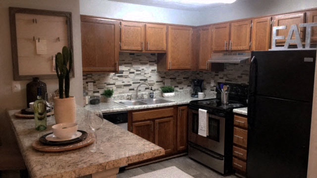 a kitchen with black appliances and wooden cabinets