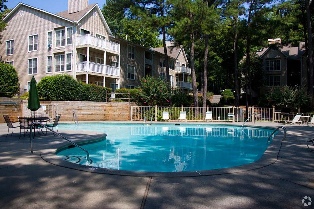 a large swimming pool in front of an apartment building