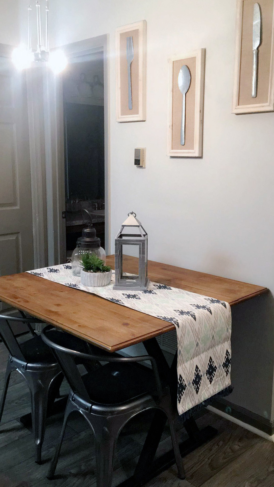 a dining room with a wooden table and black chairs