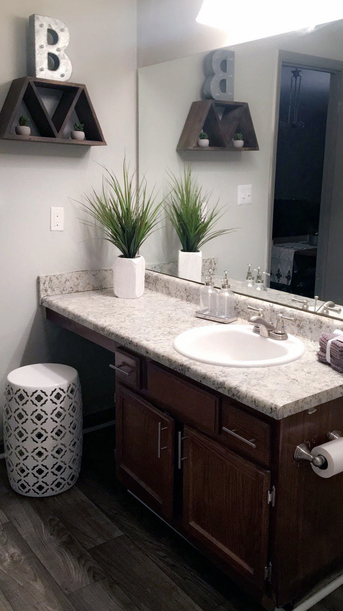 a bathroom with a sink and a mirror and a stool