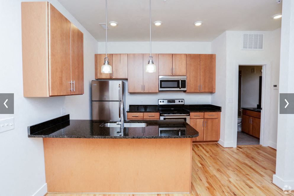 a kitchen with wooden cabinets and a black counter top