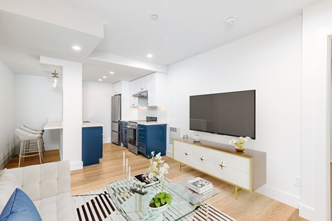 A modern living room with a glass coffee table and a television.
