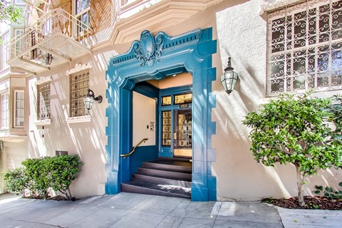 A blue doorway with a staircase leading up to it.