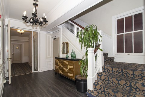 A room with a staircase and a chandelier.