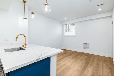 A kitchen with a white counter top and a blue counter.