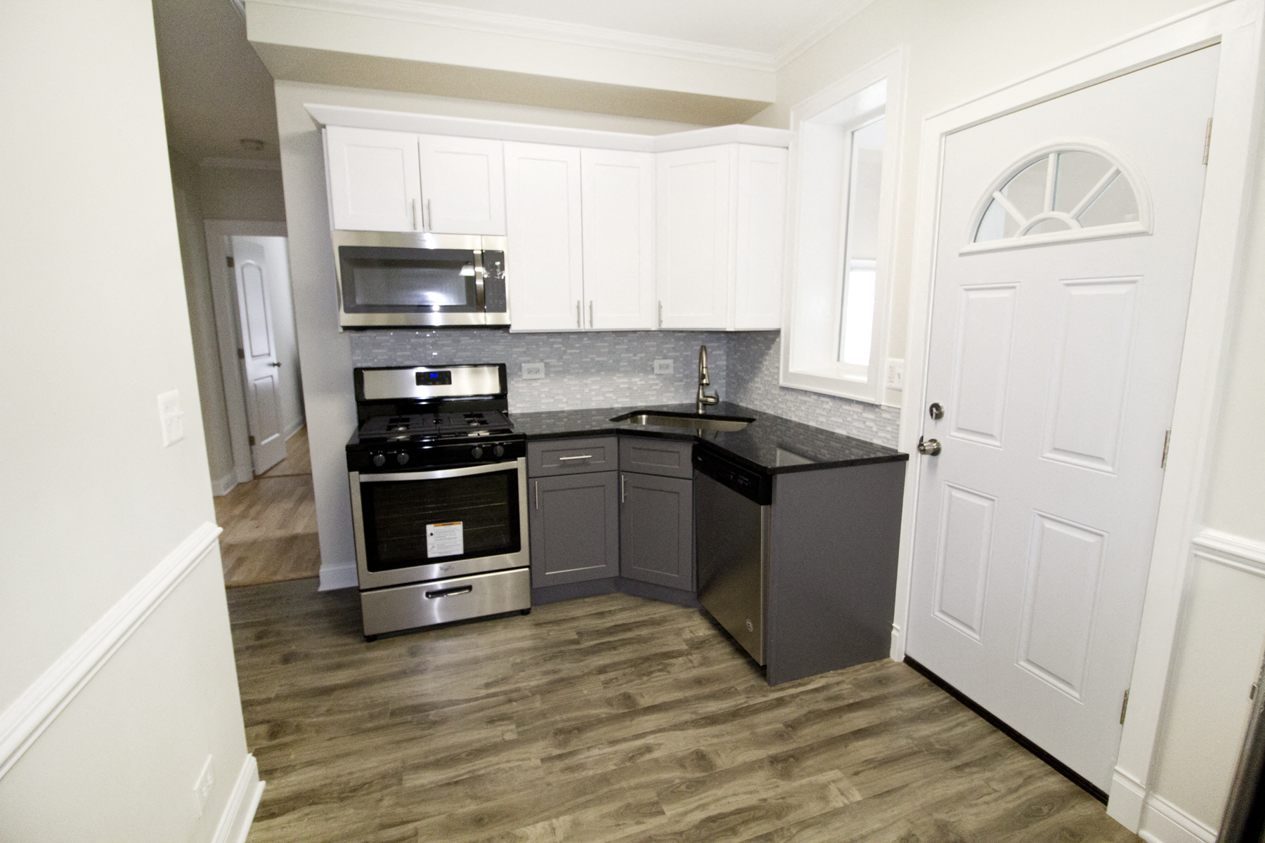 an empty kitchen with white cabinets and stainless steel appliances