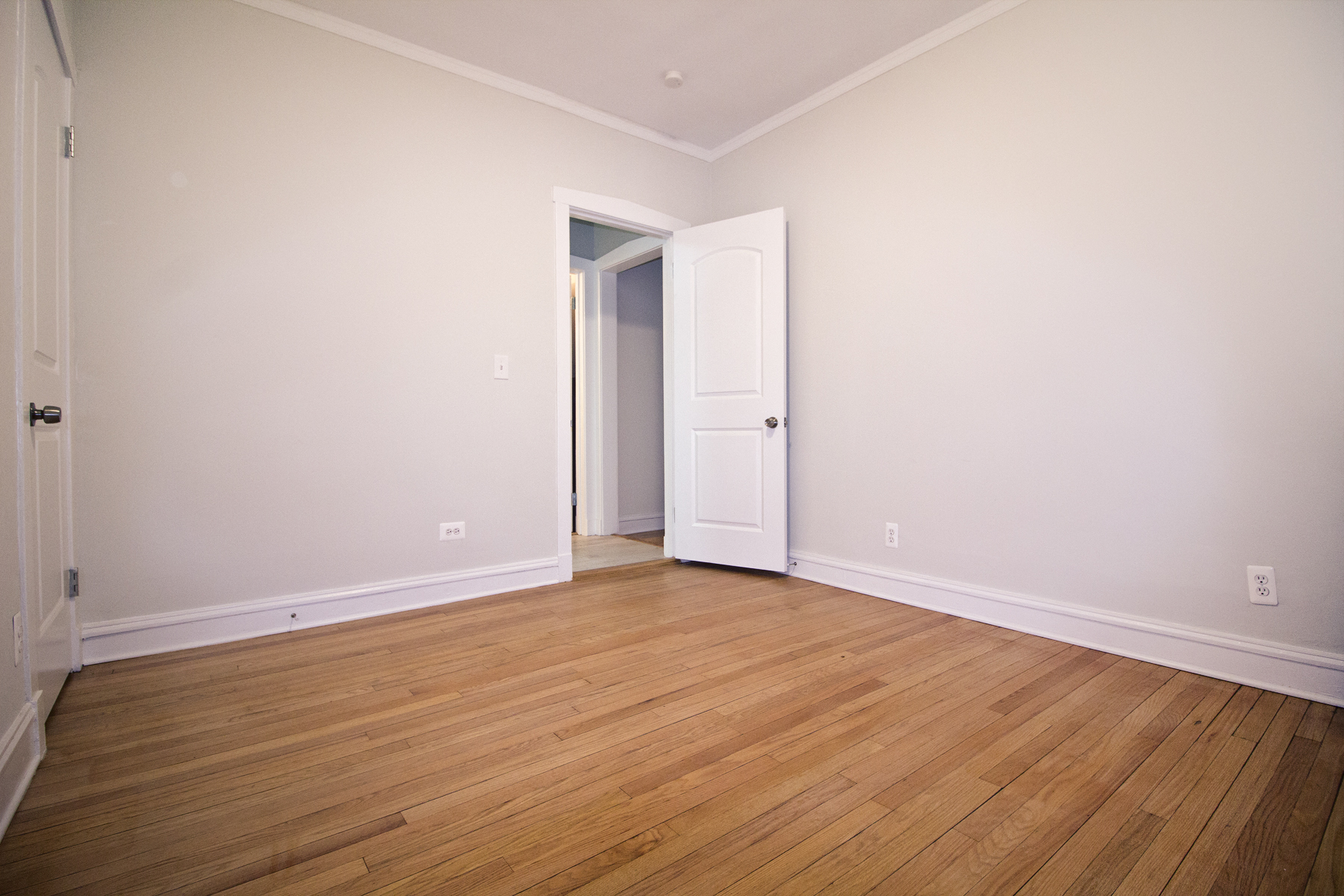 an empty living room with white walls and wood floors