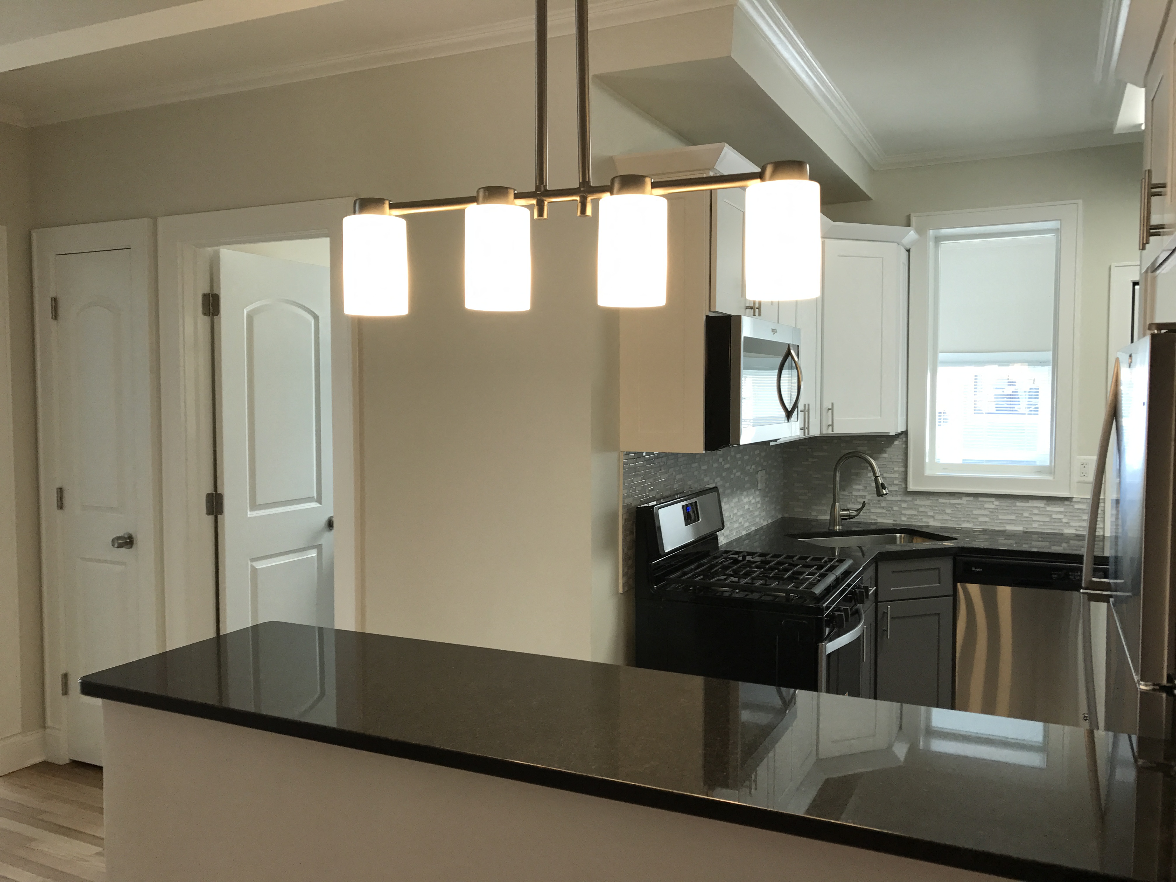 a kitchen with a black counter top and an island with lights