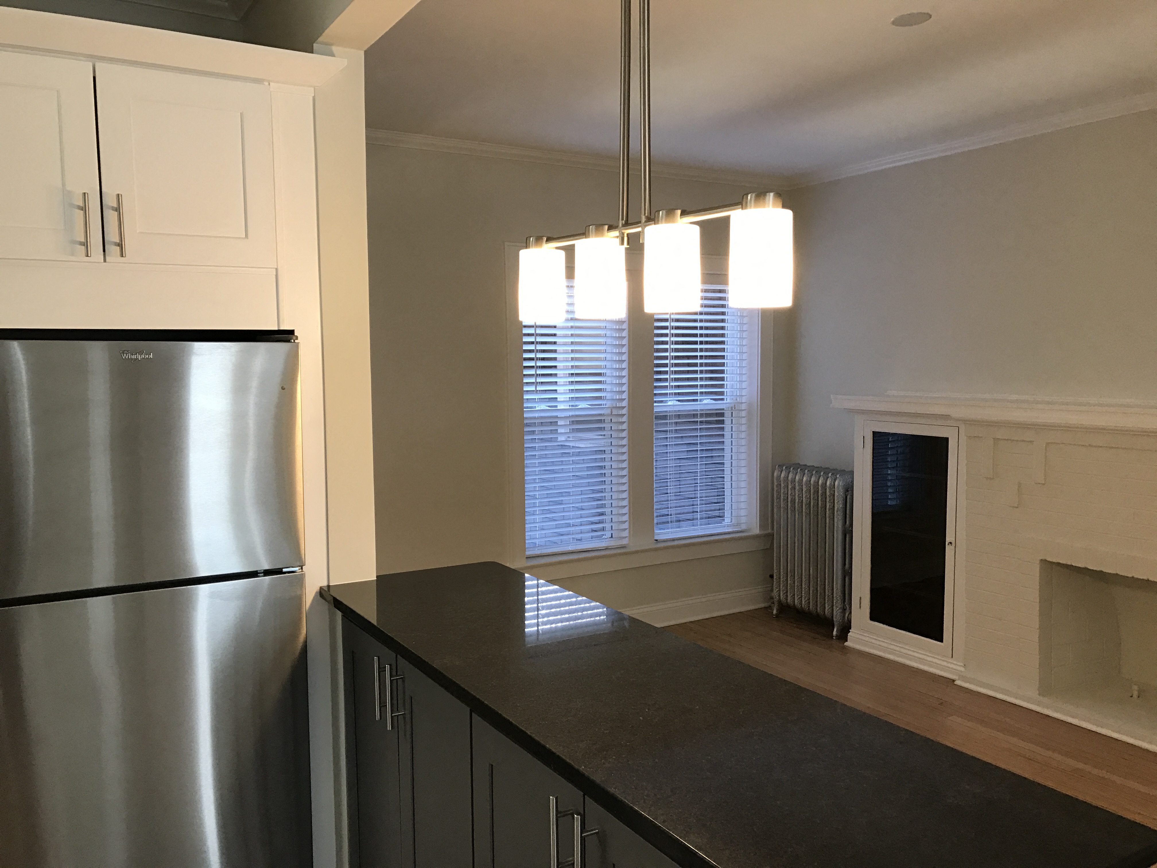 a kitchen with a large window and a stainless steel refrigerator
