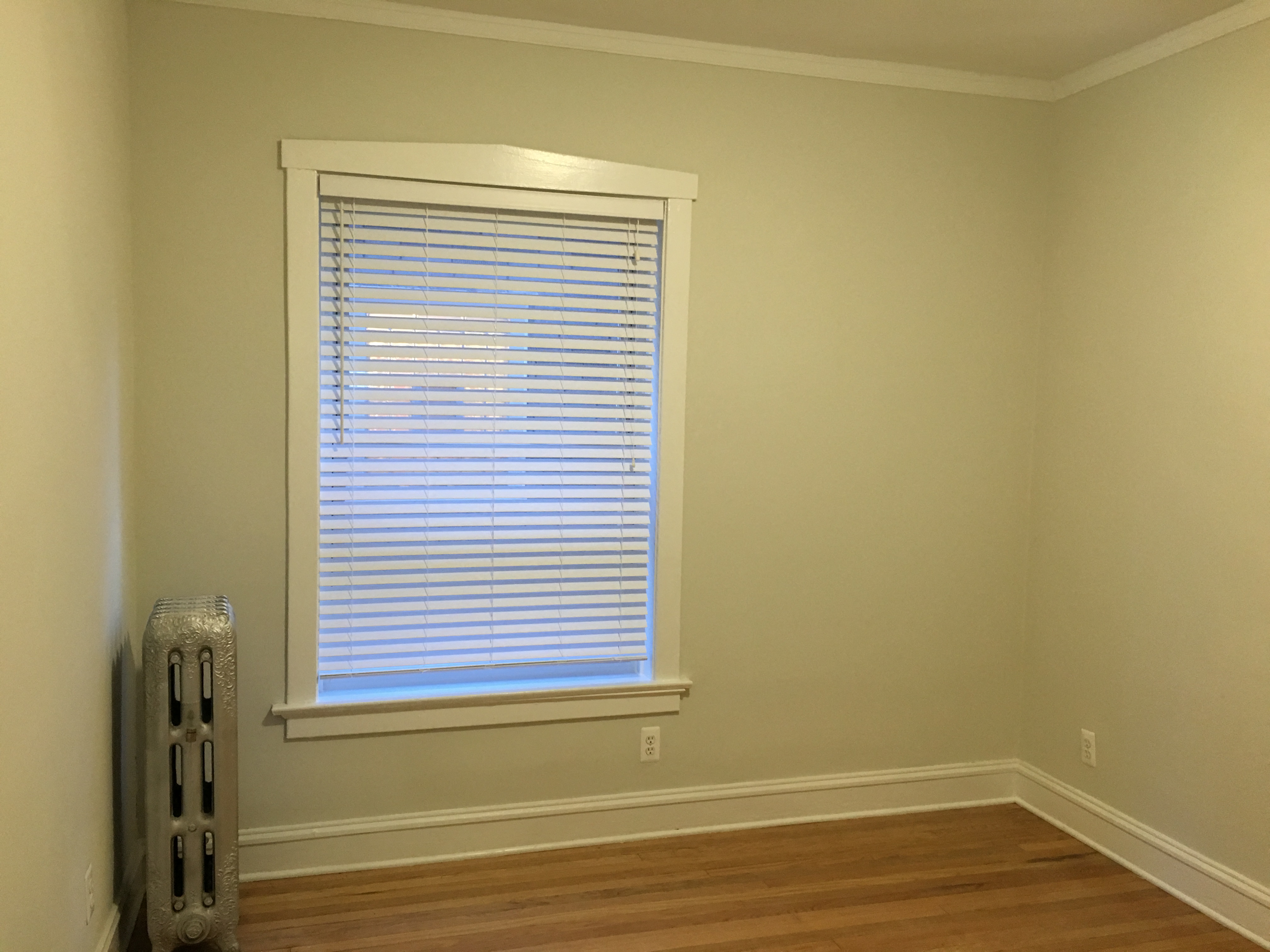 a room with a window with a wood floor and a radiator