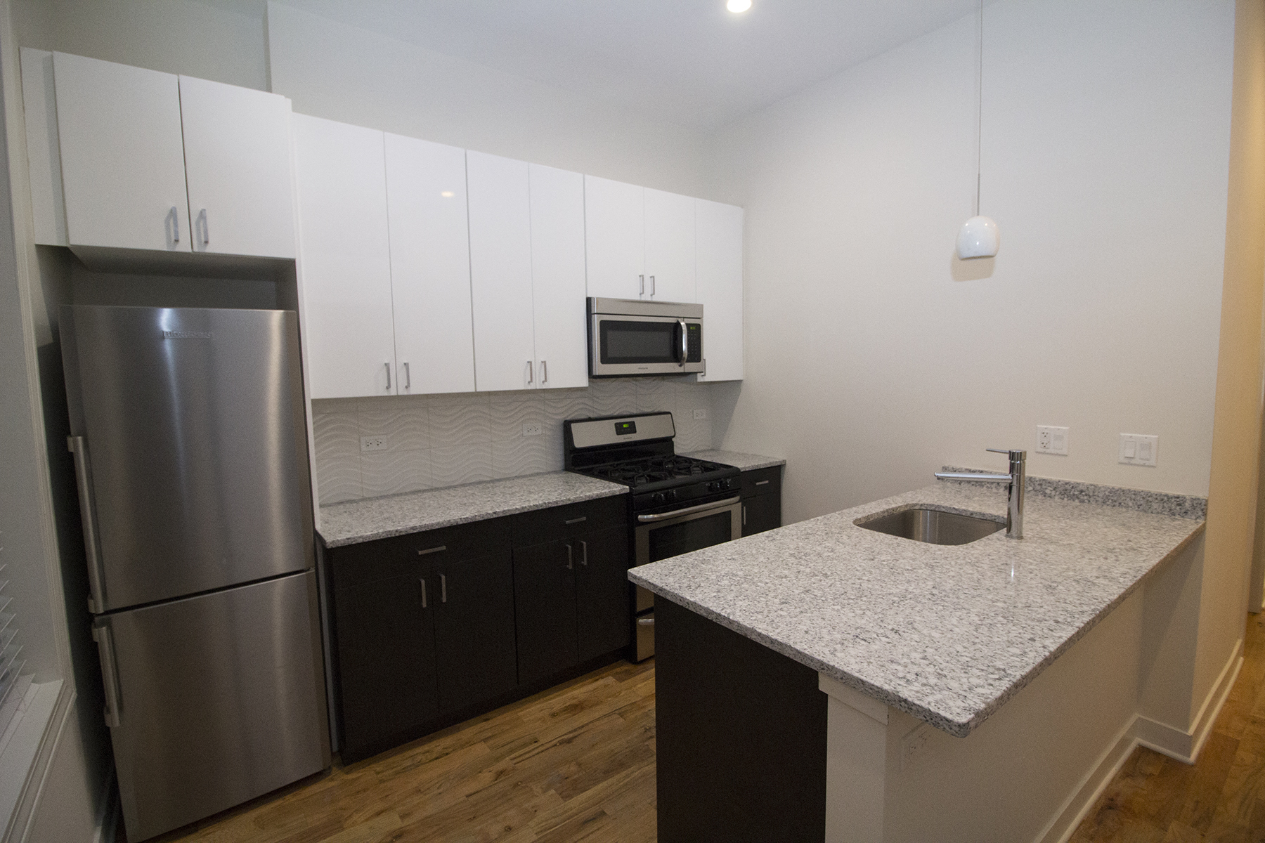 a kitchen with granite counter tops and a stainless steel refrigerator
